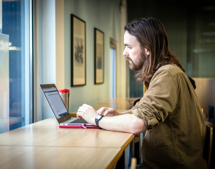 Student working on a laptop by the window in the East End campus library at Glasgow Kelvin College Student working on a laptop by the window in the East End campus library at Glasgow Kelvin College